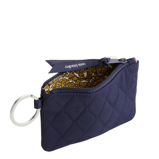 A navy blue quilted coin pouch with a silver key ring attachment and a patterned interior lining, shown on a plain white background.
