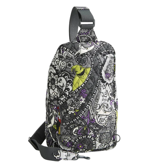 A black and white paisley patterned sling backpack with a bright lime green leaf accent, shown on a solid white background.