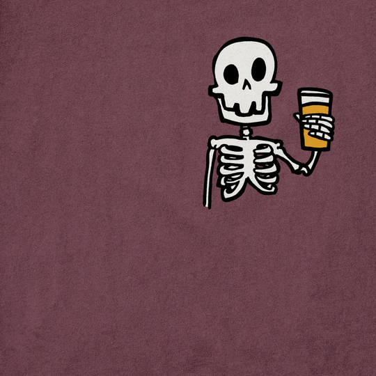 A close-up of a textured mauve or dusty purple fabric surface with a small cartoon skeleton graphic holding an orange drink near the upper right area.