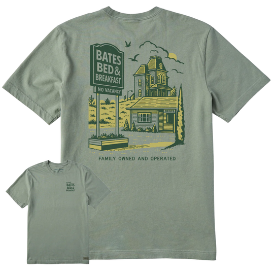 A sage green graphic t-shirt shown from both the front and back. The back features a large vintage-style illustration of a haunted house with a 'Bates Bed & Breakfast' sign, while the front has a small matching logo on the left chest.