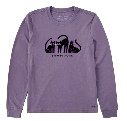 A lavender purple long-sleeve crewneck t-shirt featuring a black graphic of three cats in the shape of the word 'cats' and the text 'LIFE IS GOOD' printed on the chest.