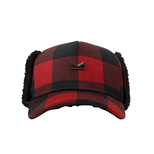 A red and black buffalo plaid winter trapper hat with black fleece ear flaps and a small metallic 'M' logo on the front, shown against a plain white background.