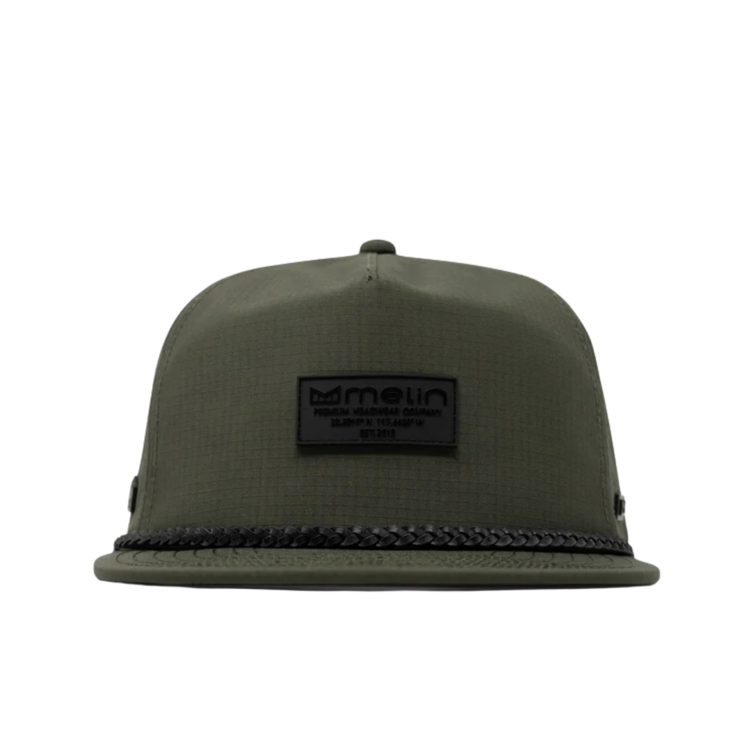 An olive green flat-brim cap with a black woven trim along the edge of the brim and a black rectangular logo patch on the front. The patch displays the brand name 'metin'.