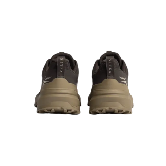 A pair of trail running shoes shown from the back, featuring a dark charcoal gray upper and a tan-brown midsole and outsole, with 'SITKA' printed vertically on the heel pull tabs.