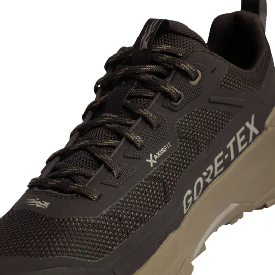 A close-up of a dark brown and black Gore-Tex trail running shoe with brown laces and a tan outsole, featuring the 'Xaxisfit' and 'GORE-TEX' branding.