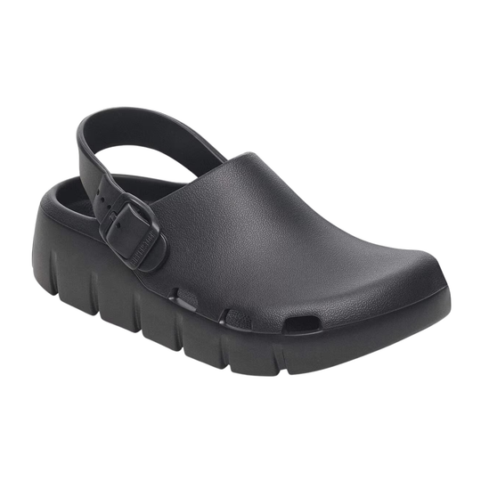 A single black clog-style shoe with a thick lug sole and a strap closure, shown on a plain white background.