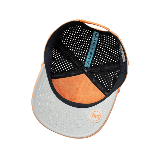 An overhead view of a baseball cap's back panel, featuring a light gray brim with a small circular logo, black mesh back, and orange side panels and trim.
