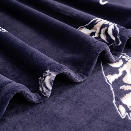 Close-up of a plush dark navy blanket with tiger print patterns and soft draped folds.