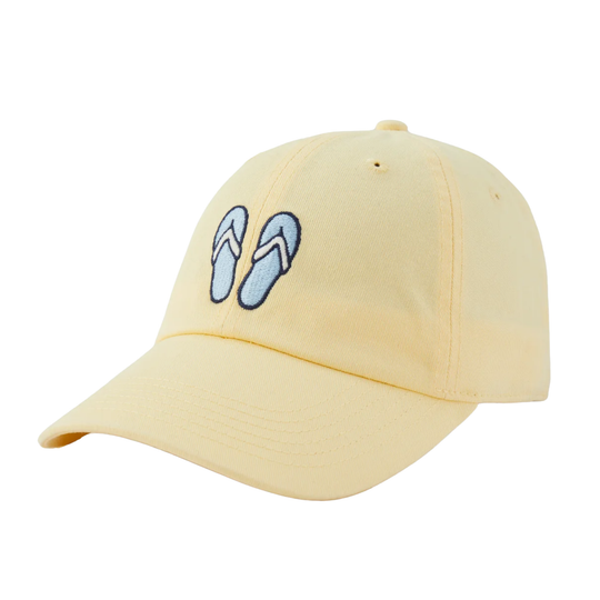 A pale yellow baseball cap featuring an embroidered pair of light blue flip-flops with dark blue outlines on the front panel, set against a plain white background.