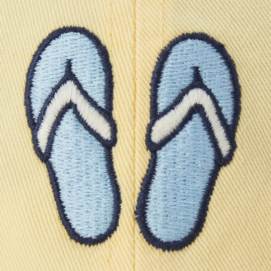 Embroidered blue flip-flops on a beige background