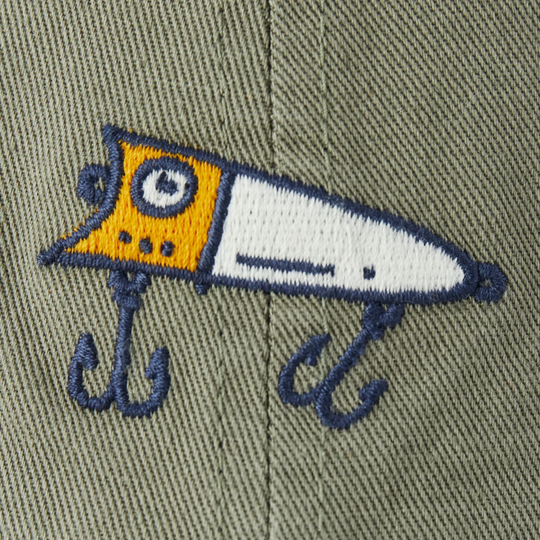 Embroidered fishing lure patch on a green fabric background