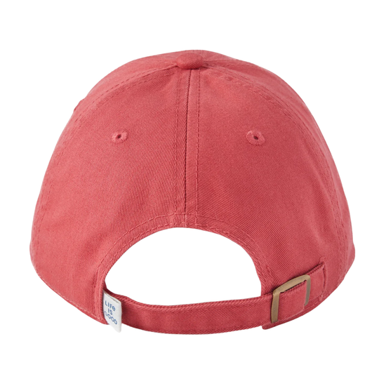 The back view of a washed coral red baseball cap with an adjustable strap and a small white brand tag.