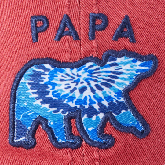 close up of an embroidered blue polar bear with a tie-dye pattern and the word 'PAPA' above it