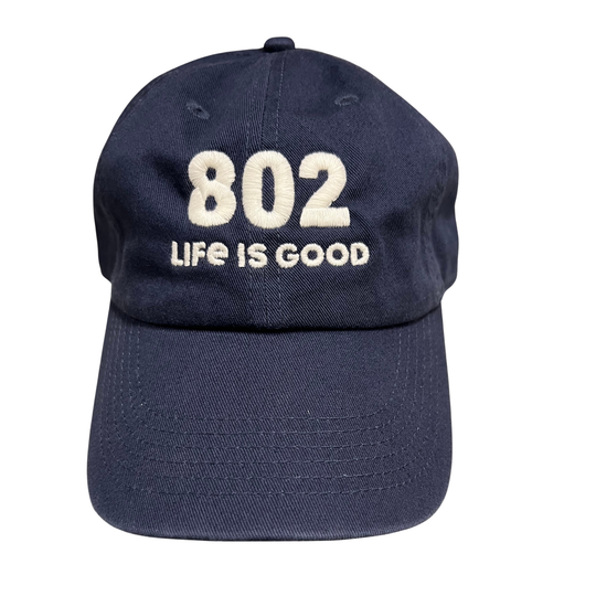 A navy blue cotton baseball cap with '802 LIFE IS GOOD' embroidered in cream on the front, shown against a plain white background.