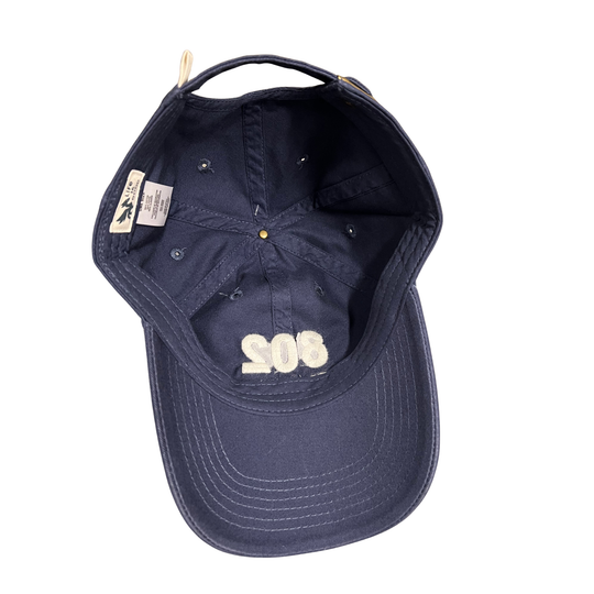 A navy blue baseball cap shown from an overhead angle, featuring a curved brim, embroidered cream '802' text on the front, and interior labels.