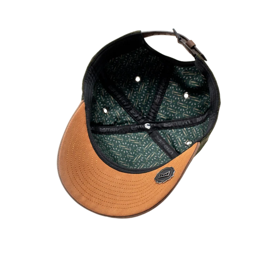 A structured baseball cap shown from a top-down angle on a plain white background. The cap features a tan leather-look brim and a dark green patterned crown with black trim and a black adjustable strap.