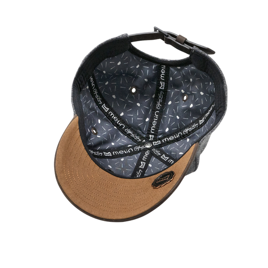 A baseball cap shown from an overhead angle, featuring a tan curved brim, a black mesh back, and a black interior patterned with white text and geometric shapes.