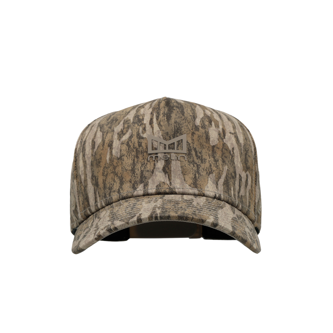 A baseball cap with a brown and beige tree bark camouflage pattern, featuring a debossed logo on the front that reads 'Melin'.