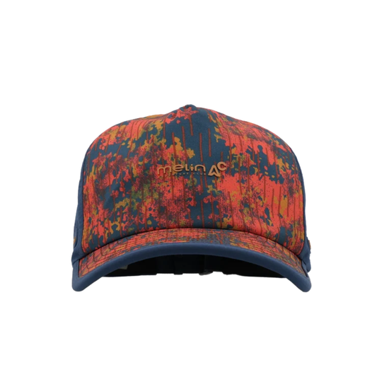 A baseball cap with a vibrant abstract paint-splatter pattern in red, orange, and navy blue, featuring a small silicon gold 'Melin' logo on the front.