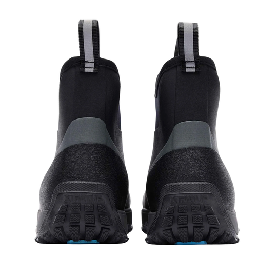 A pair of black waterproof boots shown from the back, featuring textured rubber soles with the brand name 'Kipsta' embossed on the heel and a small blue accent at the toe.