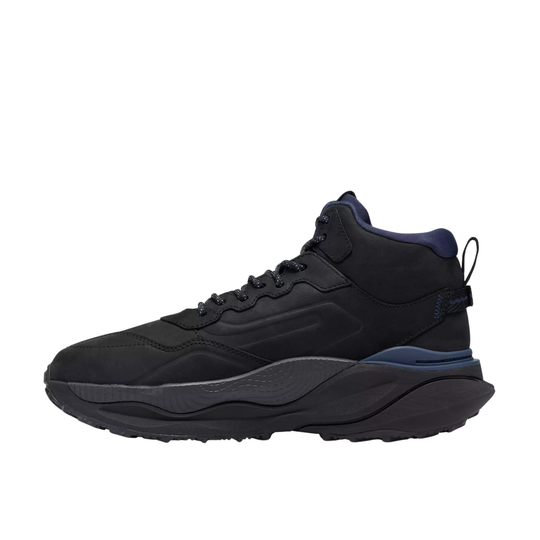 A black high-top sneaker with a chunky black and dark gray sole, featuring a navy blue collar lining and a subtle blue accent near the heel, shown from a side profile on a white background.