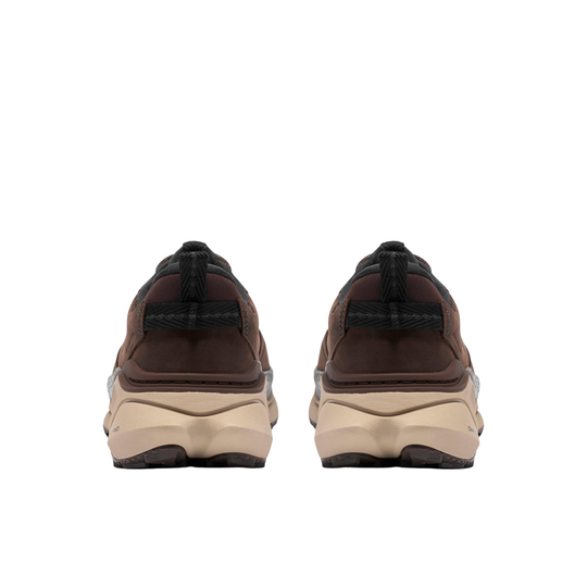 A pair of chunky platform sneakers shown from the back, featuring dark brown and black upper panels with thick beige platform soles.