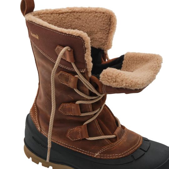 A brown leather winter boot with a tan shearling lining, thick beige laces, and a black rubber toe cap, shown on a white background.