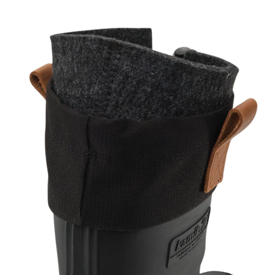 Close-up of a black rubber boot with a black fabric boot cover featuring brown leather pull tabs and a dark gray felt lining.
