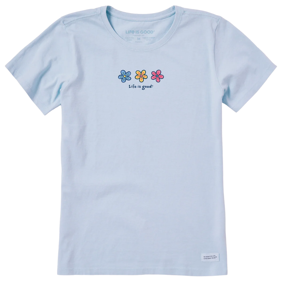 A light blue short-sleeve crewneck t-shirt by Life is GOOD, featuring three small colorful flowers (blue, yellow, pink) and the text 'life is good?' printed on the chest.
