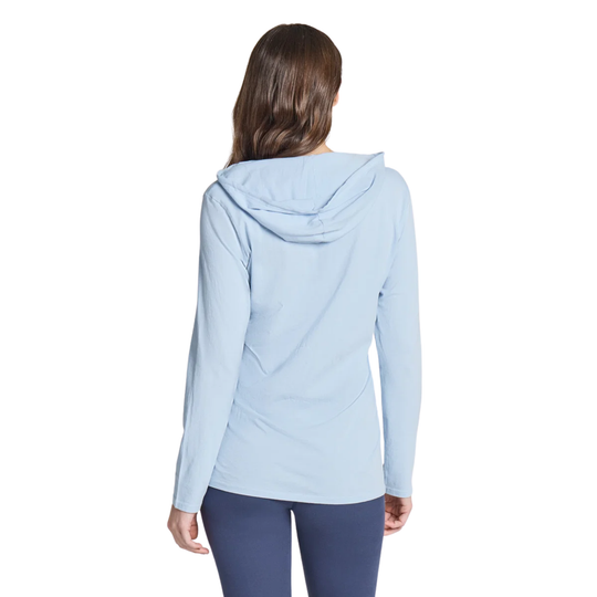 A woman viewed from the back wearing a light blue hooded long-sleeve athletic top and dark blue leggings against a plain white background.