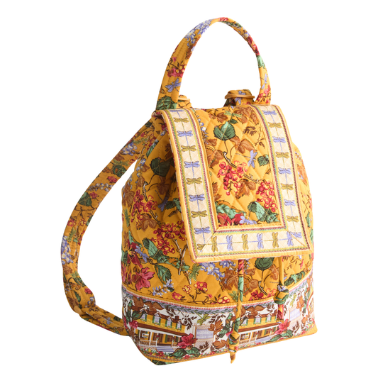 A yellow backpack with a detailed botanical and scenic print, featuring a top handle, adjustable shoulder strap, and a decorative front flap with a drawstring closure.