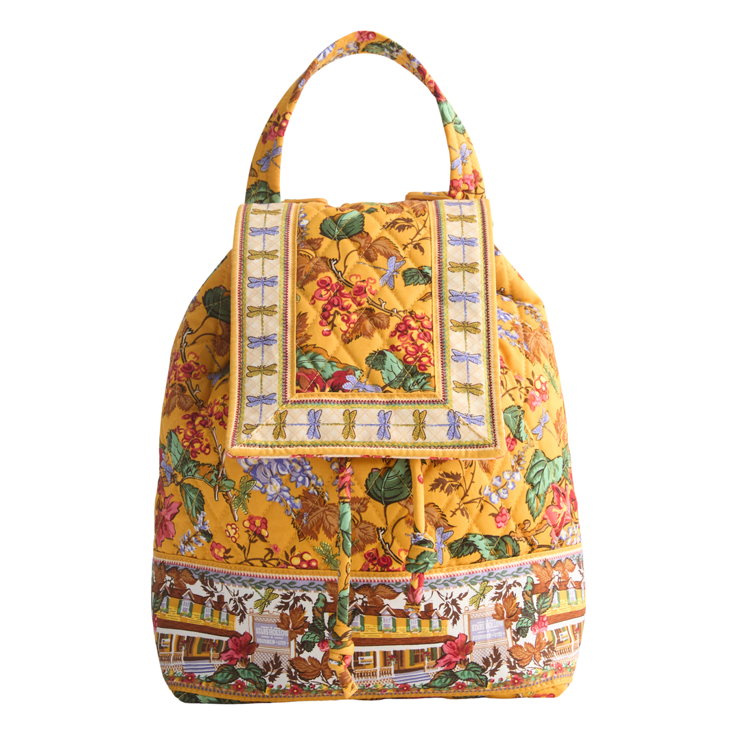 A yellow fabric handbag with a detailed multicolor floral and scenic print, featuring a top handle and a decorative front flap.