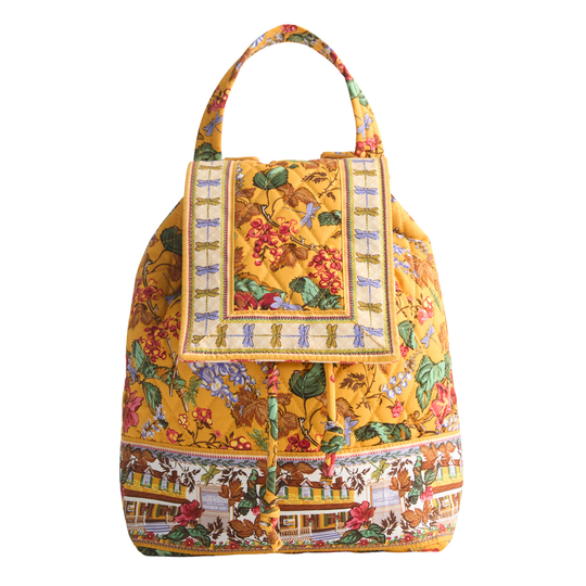 A yellow fabric handbag with a detailed multicolor floral and scenic print, featuring a top handle and a decorative front flap.