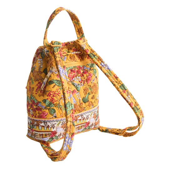 A yellow canvas drawstring bucket bag with a colorful floral and botanical print, featuring a single shoulder strap, shown against a plain white background.