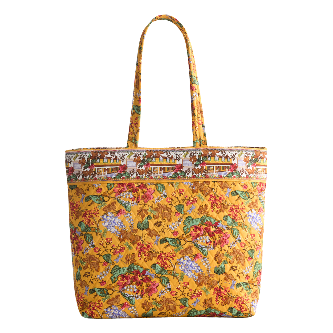 A yellow tote bag with a dense floral and botanical print, featuring a decorative border pattern along the top and matching shoulder straps, set against a plain white background.