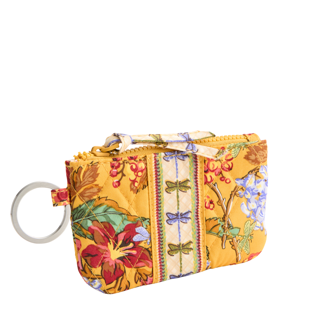 A small quilted fabric zip pouch with a floral and butterfly print on a yellow background, featuring a silver metal key ring attachment.