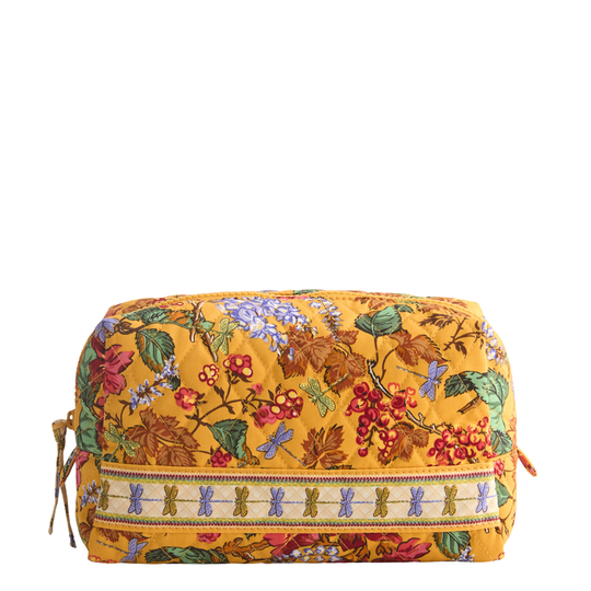 A quilted cosmetic pouch in mustard yellow with a detailed floral and botanical print, featuring a decorative embroidered band with butterfly motifs around the zipper.