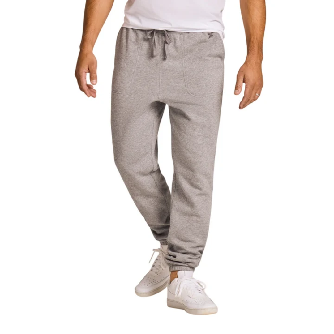 Person wearing gray sweatpants and white sneakers on a white background