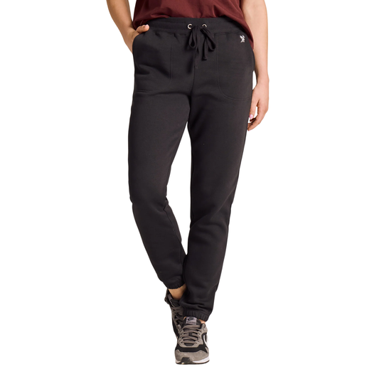 A person wearing black jogger-style pants with a drawstring waistband, shown from the waist down against a plain white studio background.