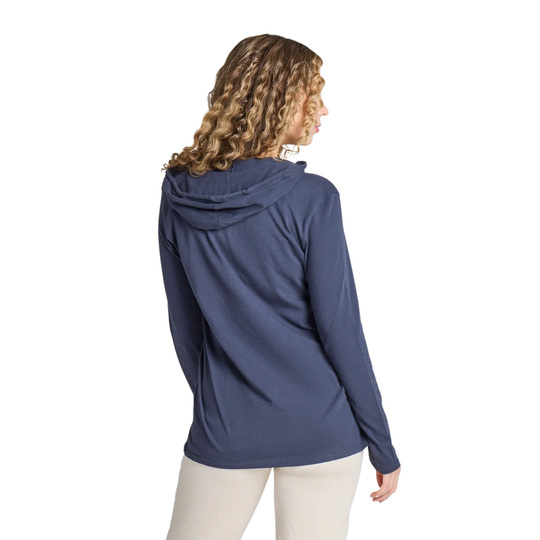 A woman with curly light brown hair is shown from the back wearing a navy blue hooded long-sleeve athletic top and light beige pants, set against a plain white background.