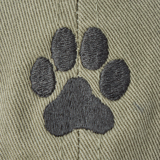 Close-up of a black embroidered paw print on a green twill fabric background.