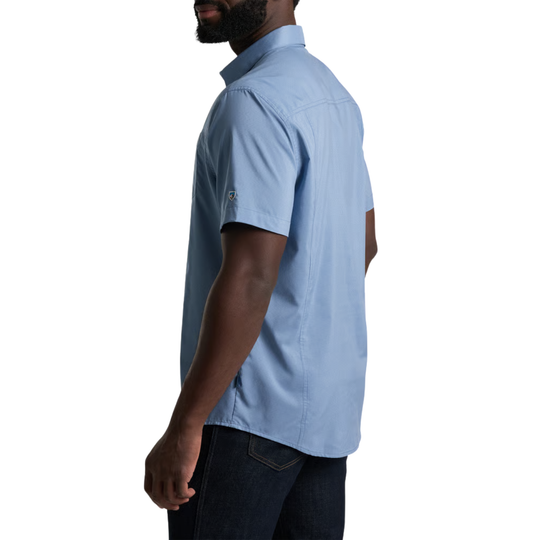A man wearing a light blue short-sleeve button-up shirt, shown from a side-back angle against a plain white background.