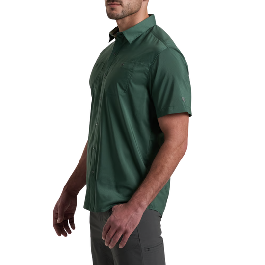 A man wearing a dark green short-sleeve button-up shirt, shown from the side against a plain white background.