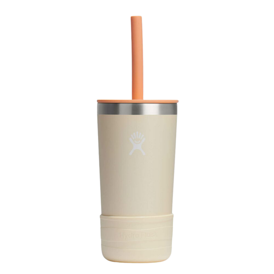 A cream-colored insulated travel tumbler with a silver metallic band, a matching cream lid, a light orange straw, and a textured cream base. The Hydro Flask logo is embossed on the front.