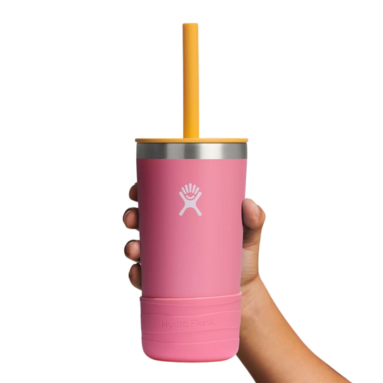 Pink tumbler with a yellow straw held by a hand on a white background
