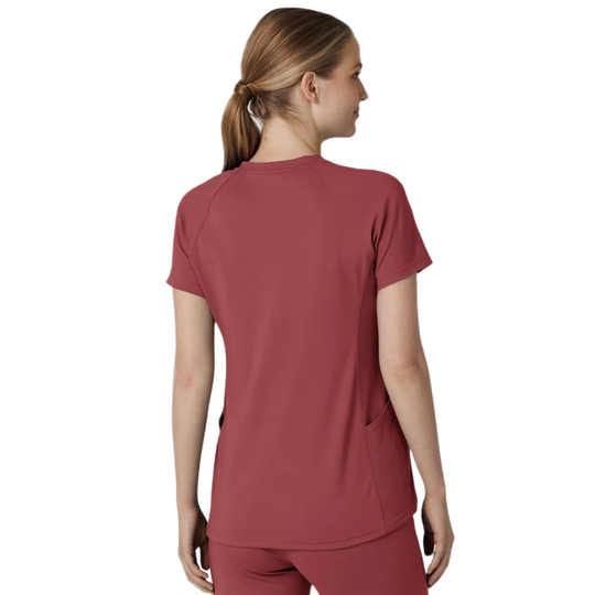 A woman shown from the back wearing a short-sleeve scrub top and matching scrub pants in a dusty rose color, set against a plain white background.