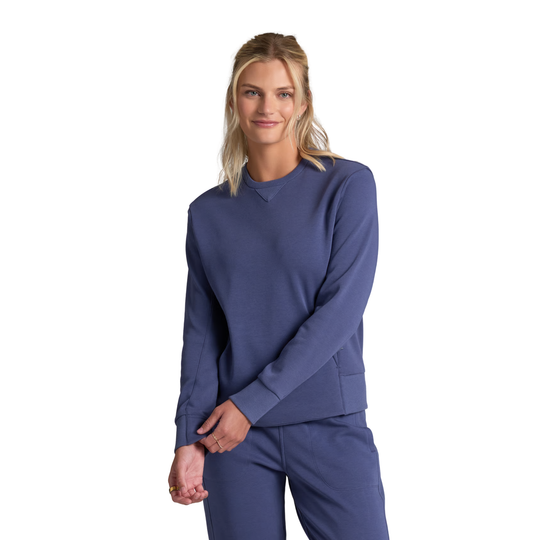 A woman modeling a matching navy blue long-sleeve top and pants set against a plain white background.