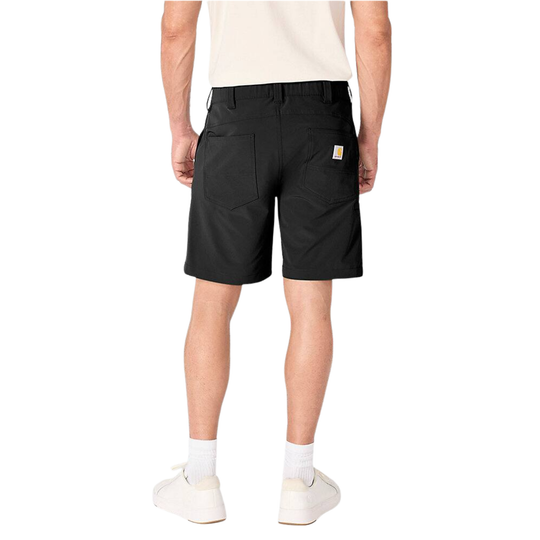 A person shown from the back wearing black Carhartt work shorts, a cream t-shirt, white socks, and white slip-on shoes against a plain white studio background.
