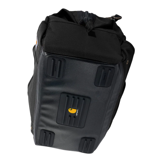 A black Carhartt bike pannier bag shown from a three-quarters angle, displaying its front zipper, textured front panel with rubberized corner protectors, and the yellow Carhartt logo.