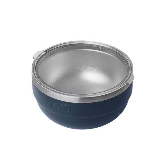 A YETI insulated bowl with a navy blue exterior, brushed silver stainless steel interior, and a clear lid, shown on a solid white background.